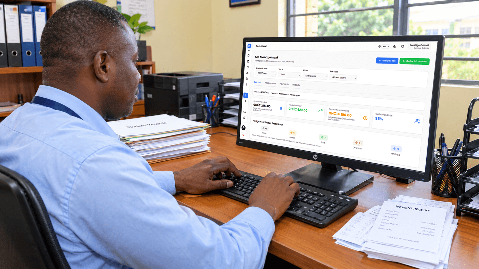 A school administrator recording a fee payment on a computer