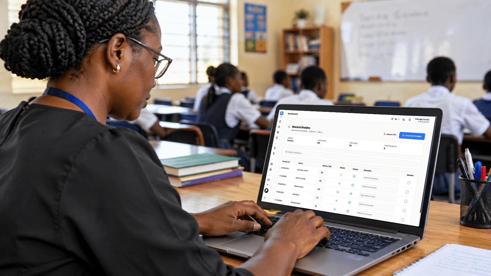 A teacher entering student scores on a laptop in a classroom